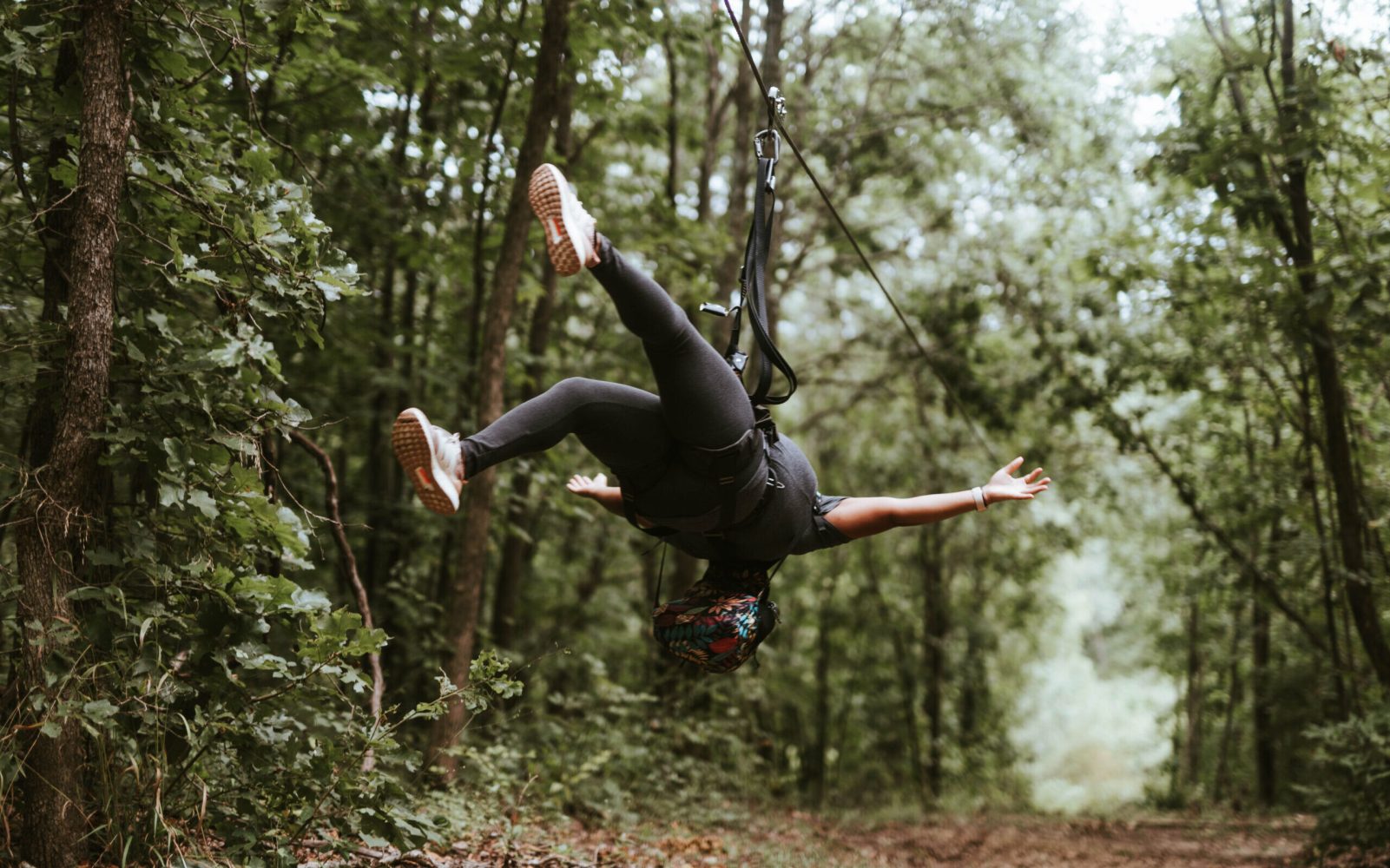 a man jumping in the air in front of a tree