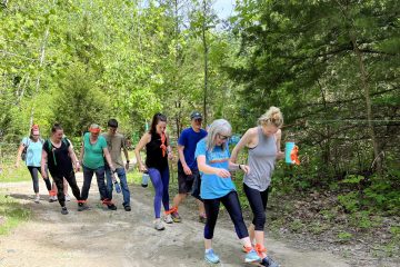 A team Building group on a dirt road in the woods participating in the Three Legged hike.