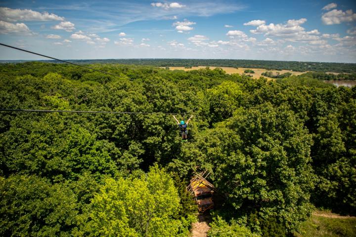 a large green field with trees in the background