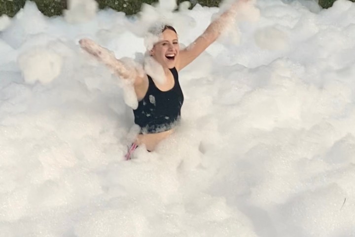 a young girl riding a wave on a surfboard in the snow